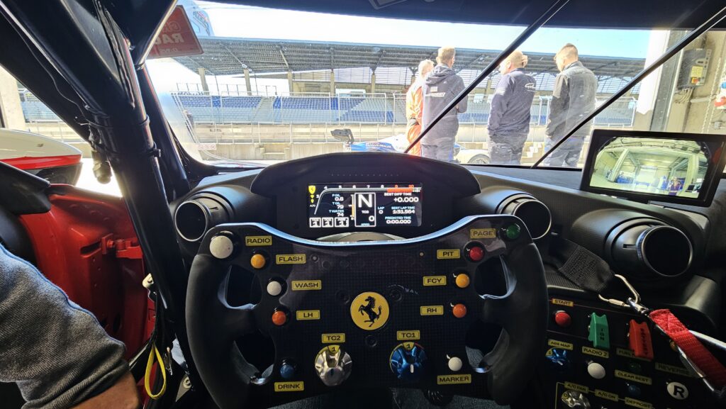 Lenkrad und Anzeige des Ferrari 296 Challenge aus der Fahrerperspektive